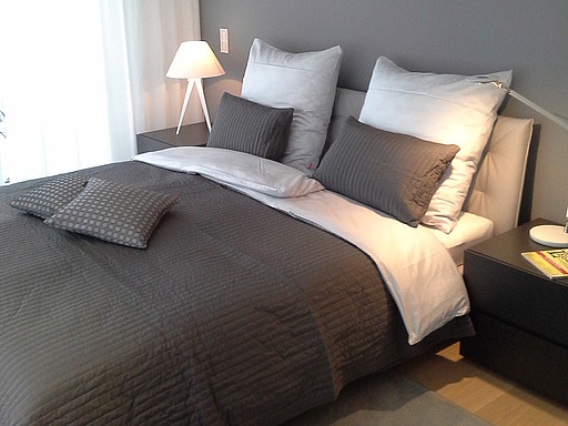 Unsere Schlafzimmerprojekte Penthaus München Schlafzimmer mit Bett und Bettwäsche bei Mebart